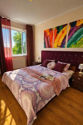 a bedroom with a bed with a large painting on the wall at Best Two Room Apartment in Mukacheve