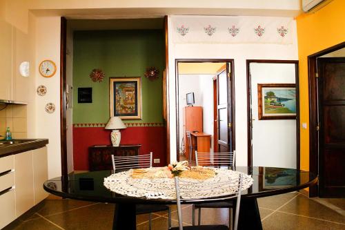 a dining room with a table and a kitchen at Guesthouse Stazione Pisa Centro in Pisa