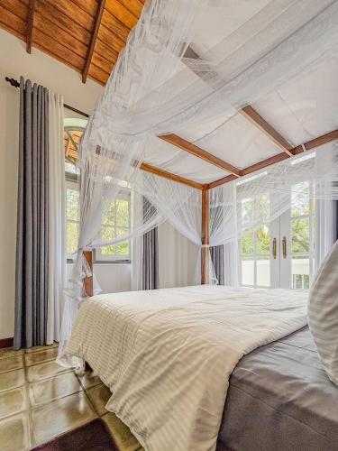 a bedroom with a white bed with a canopy at Villa House in Miriswatta