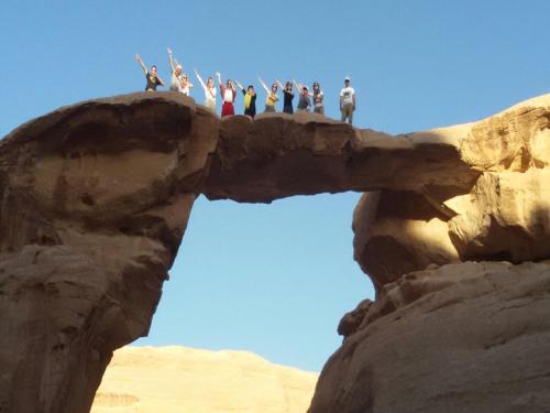 a group of people standing on top of a rock formation at Wadi Rum Quiet Village Camp in Wadi Rum