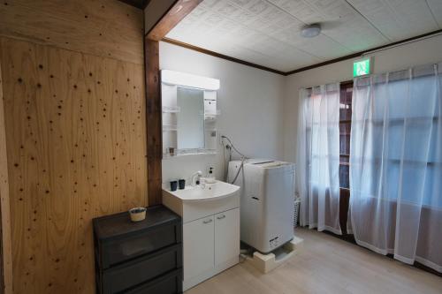 a bathroom with a sink and a refrigerator at Hareumi in Tamano