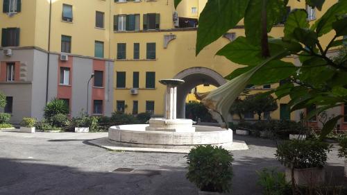 una fontana in un cortile di fronte a un edificio di Underground Rome's Room a Roma