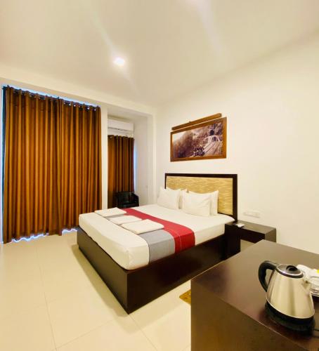a hotel room with a bed and a desk at Hotel Kandyan View ''Free pickup from Kandy city'' in Kandy
