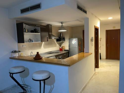 a kitchen with a counter and stools in it at Saada in Tangier
