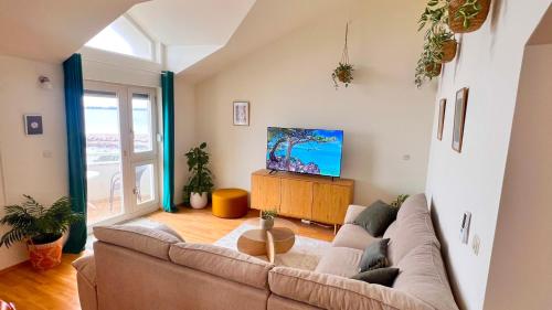 a living room with a couch and a tv at Luxury Beach Villa, Sibenik in Šibenik