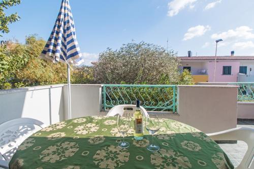 a table with a bottle of wine sitting on a balcony at Albergo Residenziale Gli Ontani in Cala Liberotto