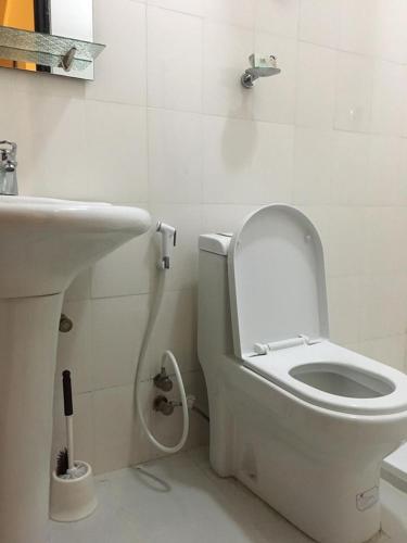 a bathroom with a white toilet and a sink at Cheers Bed & Breakfast in Addis Ababa