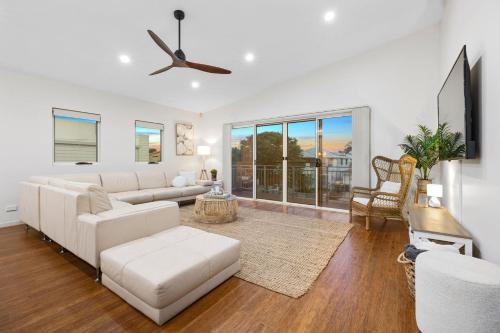 a living room with a couch and a tv at Surfmist by the Beach Pet Friendly with Pool in Kingscliff