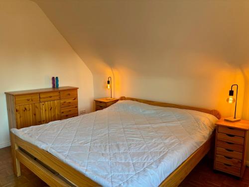 a bedroom with a bed and two dressers and two lamps at Beehome Wietzendorf in Wietzendorf
