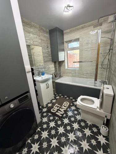 a bathroom with a toilet and a tub and a sink at Jerry's lane 3 bed house free parking free wifi in Birmingham