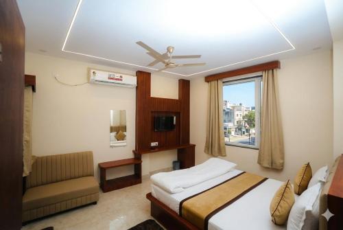 a bedroom with a bed and a couch and a window at The Gripa Hotels in Chitrakoot