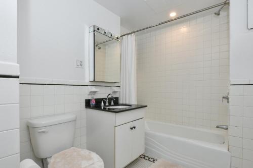 a bathroom with a toilet and a sink and a tub at Luxury 3 Bedroom Retreat in Downtown Manhattan in New York