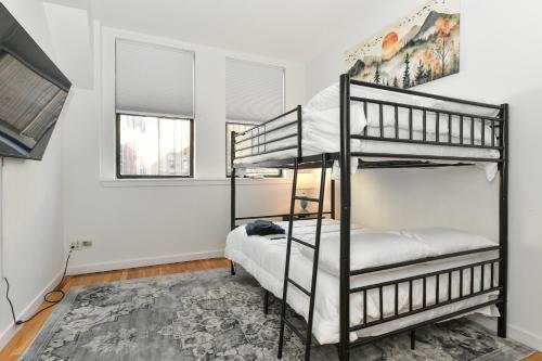 a bedroom with two bunk beds and two windows at Luxury 3 Bedroom Retreat in Downtown Manhattan in New York