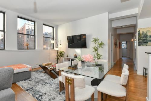 a living room with white furniture and windows at Luxury 3 Bedroom Retreat in Downtown Manhattan in New York