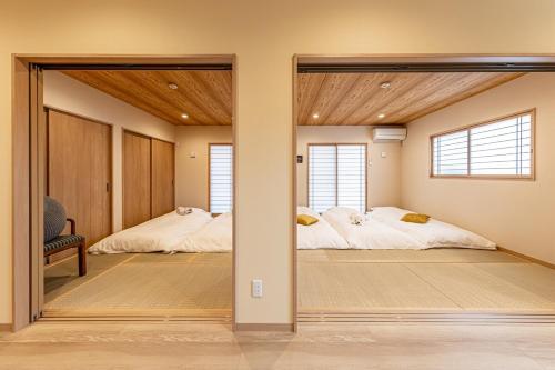two beds in a room with two windows at The Bear ベアSpacious Holiday Villa in Inzai