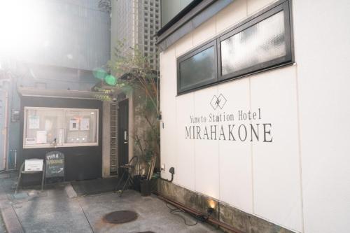 a building with a sign on the side of it at Yumoto Station Hotel MIRAHAKONE in Hakone