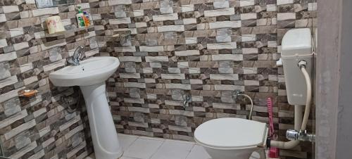 a bathroom with a toilet and a sink at Alavyahomestay in Kilba