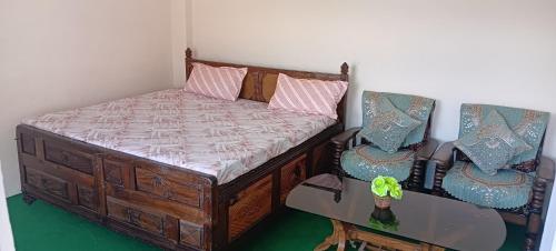 a bedroom with a bed with two chairs and a table at Alavyahomestay in Kilba