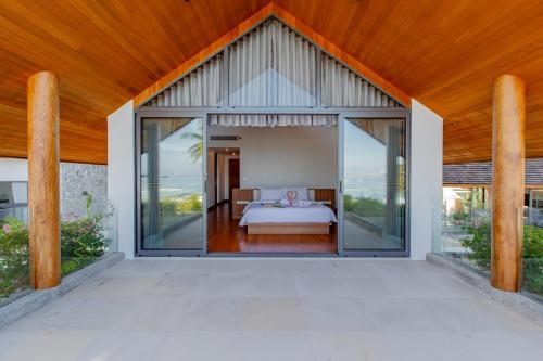a bedroom with a bed inside of a house at Masima Samui Villa in Koh Samui