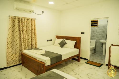 a bedroom with a bed and a bathroom with a toilet at T P Villas in Nilaveli