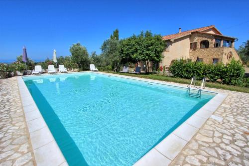 a swimming pool in front of a house at Guardistallo by PosarelliVillas in Guardistallo