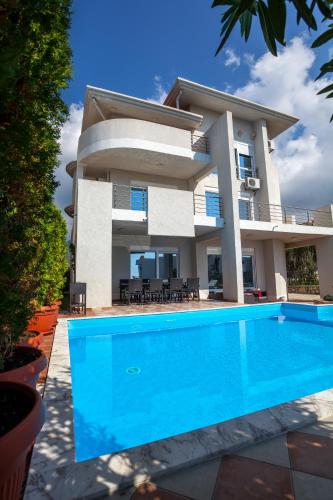 a villa with a swimming pool in front of a house at Royal Villas in Dobra Voda