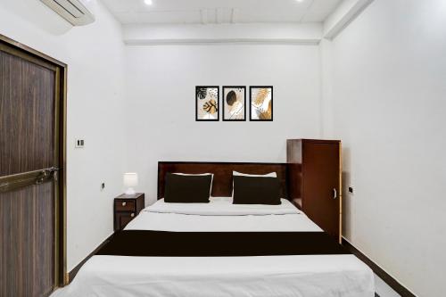 a bedroom with a large bed with black and white sheets at OYO Hotel O Ayodhya Dham Bus Terminal Formerly Om Palace in Ayodhya