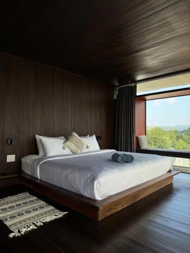 a bedroom with a large bed with a large window at NANO Eco-Hostel in Hue
