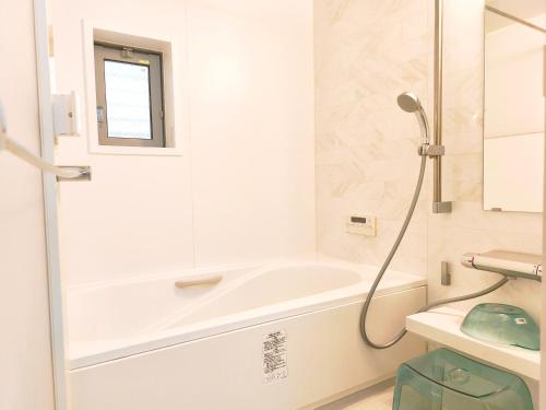 a bathroom with a bath tub and a sink at 竹内公寓 in Ichikawa