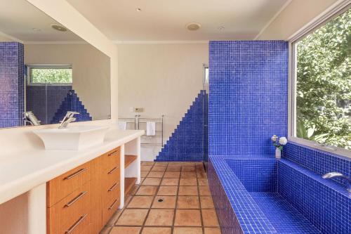a bathroom with a sink and a blue shower at Meelup Vista in Dunsborough