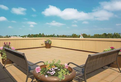 two chairs and a flower pot on a balcony at La Quinta Inn by Wyndham Vancouver Airport in Richmond