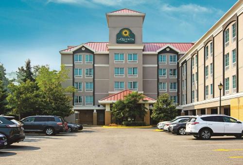 a hotel with a clock tower on top of a parking lot at La Quinta Inn by Wyndham Vancouver Airport in Richmond
