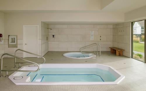 a bath room with a tub in a room at Balcomo, a Ramada by Wyndham in Penticton