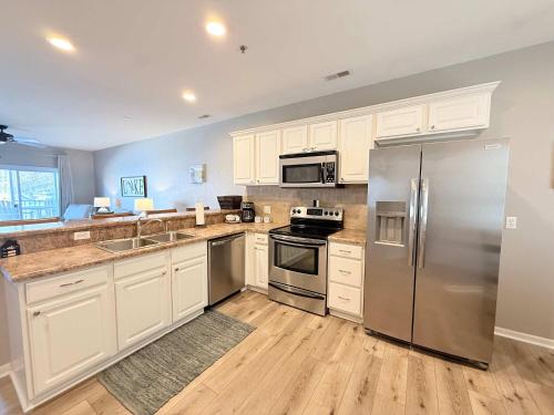 a kitchen with white cabinets and stainless steel appliances at Lakeside Sunrise Water Views in Camdenton