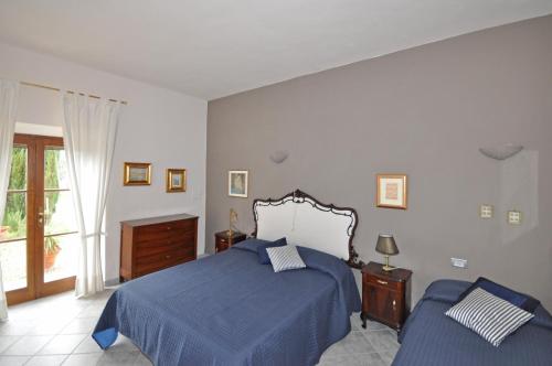 a bedroom with a blue bed and a window at Guardistallo by PosarelliVillas in Guardistallo