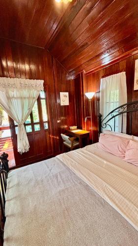 a bedroom with a bed with a wooden wall at Rang Robin Farmstay with swimming pool in Ban Wang Muang