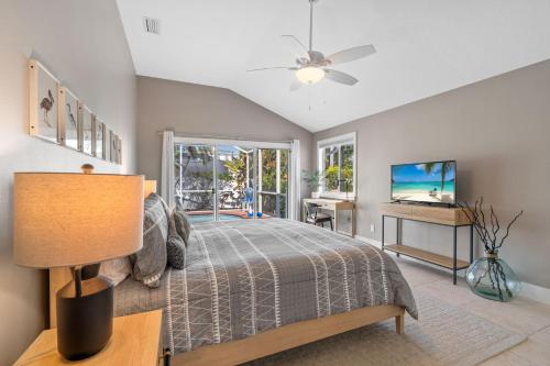 a bedroom with a bed and a ceiling fan at Enclosed pool spa - Stillpoint by SeaBreeze Vacation in Holmes Beach