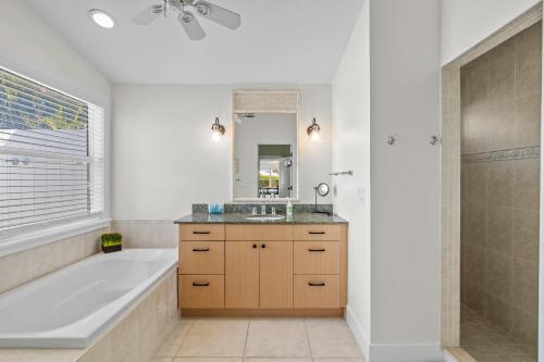 a bathroom with a tub and a sink and a tub and a shower at Enclosed pool spa - Stillpoint by SeaBreeze Vacation in Holmes Beach