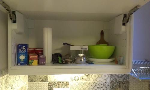 a kitchen shelf with a green bowl and other kitchen items at Budanest Apartments in Budapest