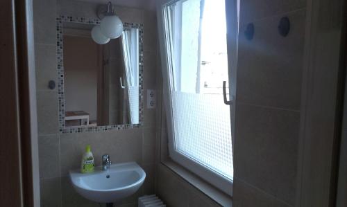 a white bathroom with a sink and a window at Budanest Apartments in Budapest