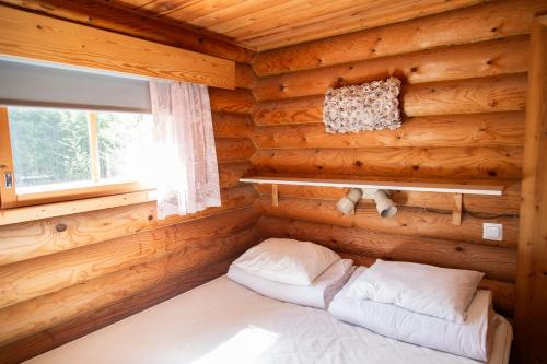 a bedroom with a bed in a log cabin at Artunpirtti in Keuruu