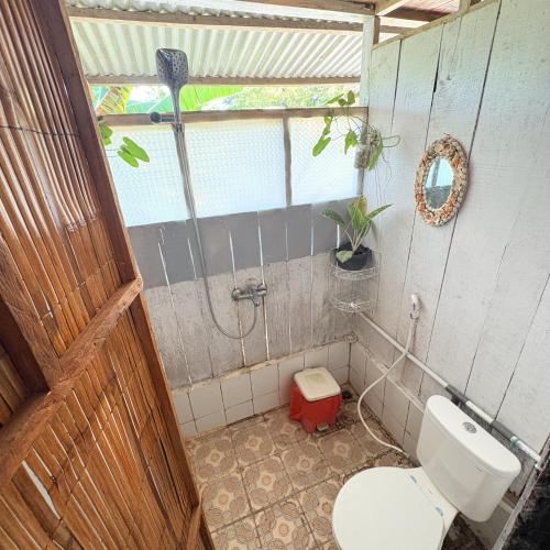 a bathroom with a toilet and a shower in it at Rumsram Homestay by Rumah Etnik Papua Sorong in Papermaranda