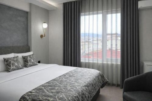 a hotel room with a bed and a large window at Medi Otel in Samsun