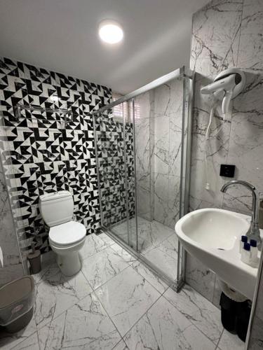 a bathroom with a toilet and a shower and a sink at Medi Otel in Samsun