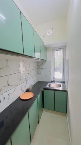 a kitchen with green cabinets and a sink at Sign Valley in Cochin