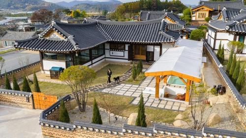 a person standing in front of a house with a dog at Gyeongju Oru Hanok Stay in Gyeongju
