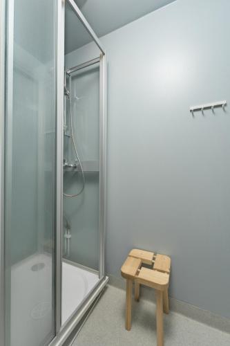 a shower with a bench next to a shower stall at Jääskän Loma Hostelli Antin Tupa in Härmä