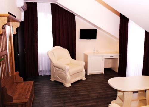 a room with a chair and a desk and a tv at Hotel Restaurant Complex Roman'S in Vishenki