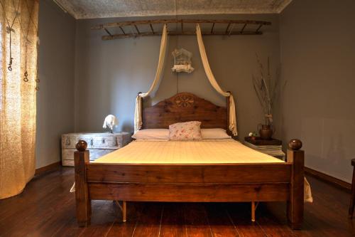 1 dormitorio con cama de madera con marco colgante en La mia casa di campagna, en Rovieto