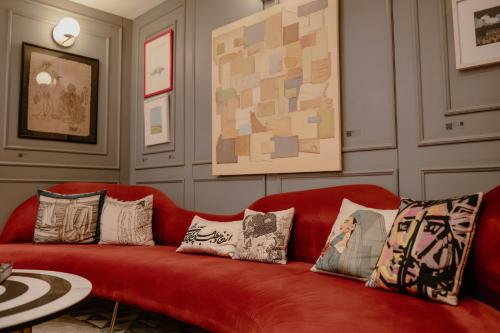 ein rotes Sofa mit Kissen in einem Wohnzimmer in der Unterkunft Ambiance Boutique Art Hotel Lahore in Lahore